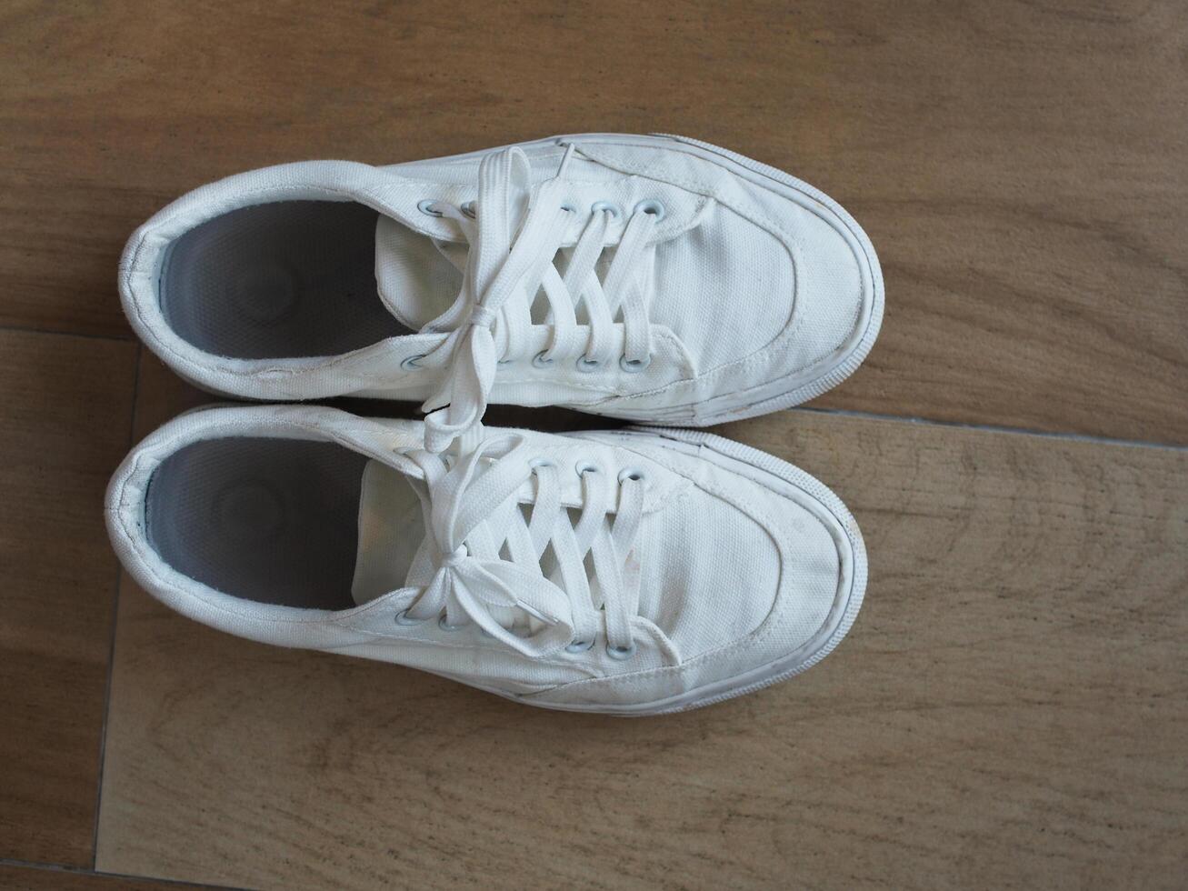 white canvas shoes on green and wooden backgrjound classic style easy and smooth life style photo