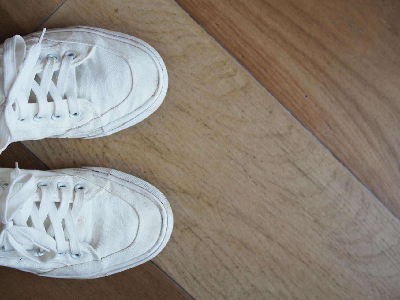 white canvas shoes on green and wooden backgrjound classic style easy and smooth life style photo