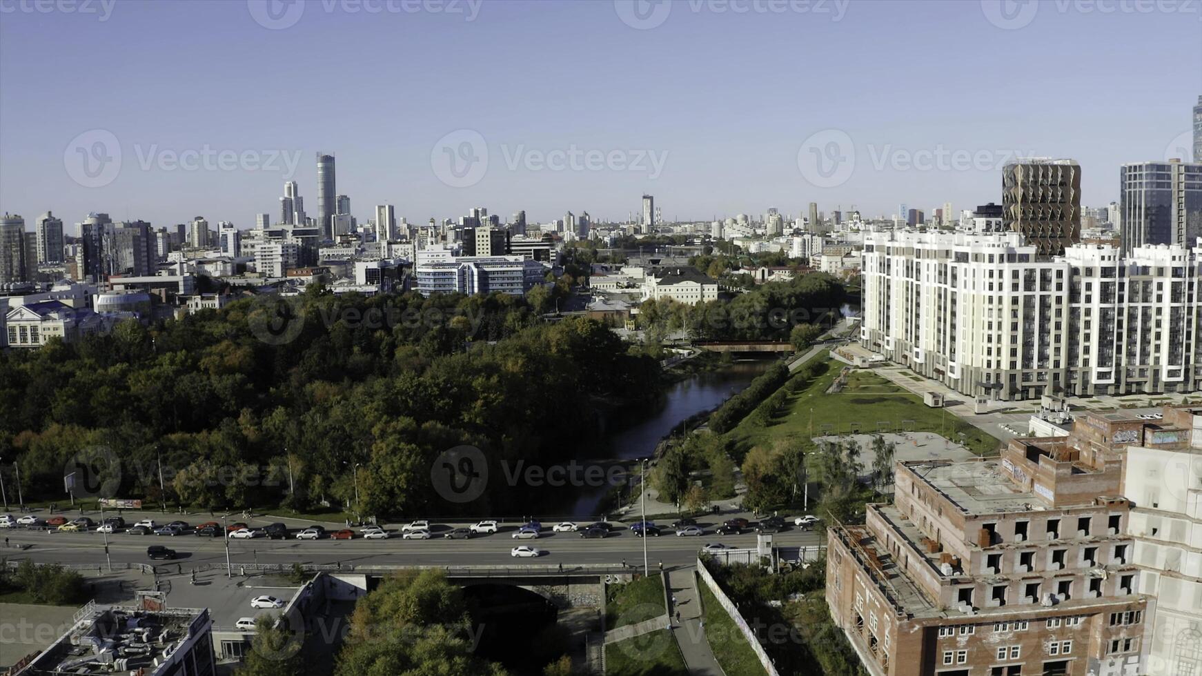 Aerial view of a modern big city with central streets on a summer day. Stock footage. Green park and river near buildings. photo