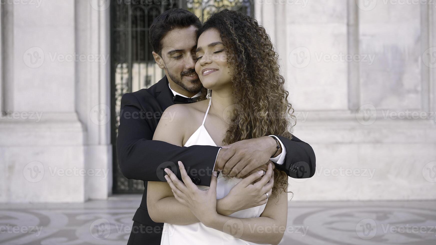 Elegant couple in love embraces on street. Action. Beautiful couple tenderly and lovingly embrace on date. Elegant couple tenderly embrace on street of romantic city photo