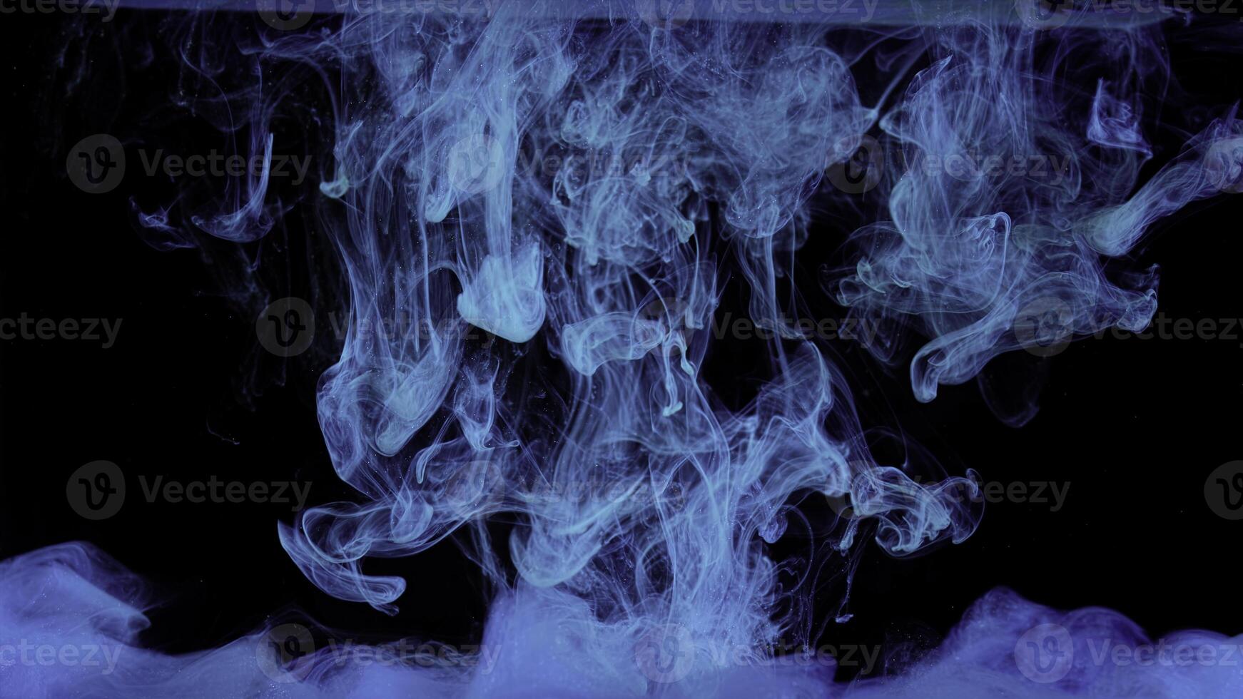Blue inks spreading in water isolated on black background. Stock footage. Breathtaking flow of bright colorful paints looking like jellyfish, art concept. photo