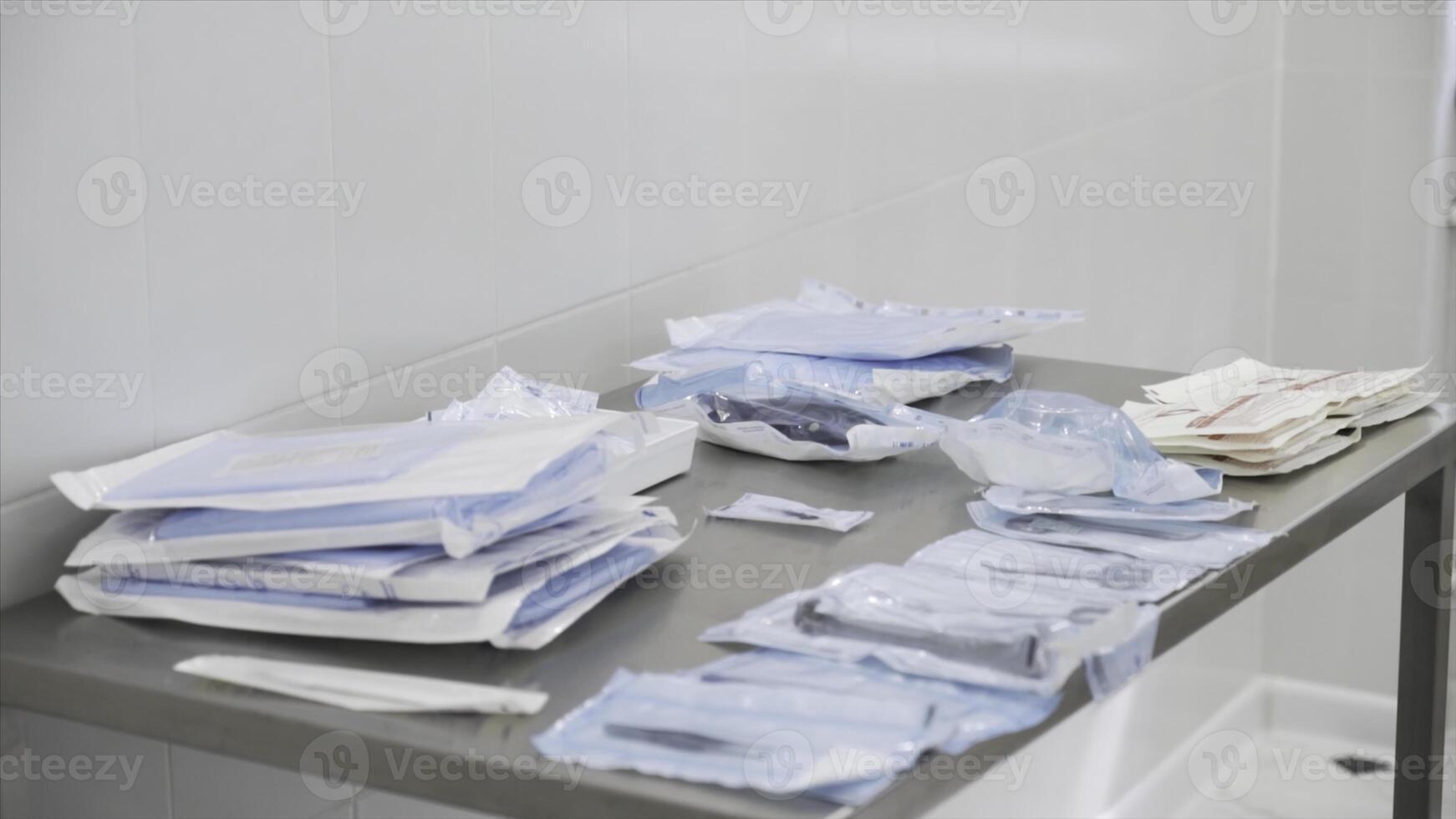 Medical laboratory details, a set of sterile disposable instruments lying on the table. Action. Close up of medical tools, surgical equipment, concept of medicine. photo