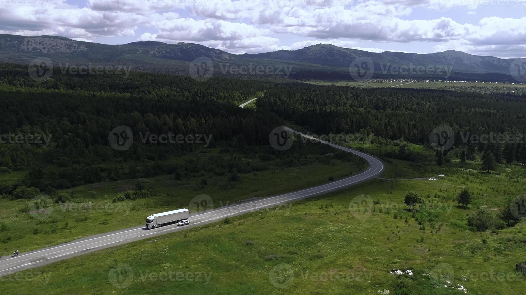 aéreo ver de un largo doblar la carretera y verde prado o campo en nublado cielo antecedentes. escena. hermosa verano naturaleza. foto