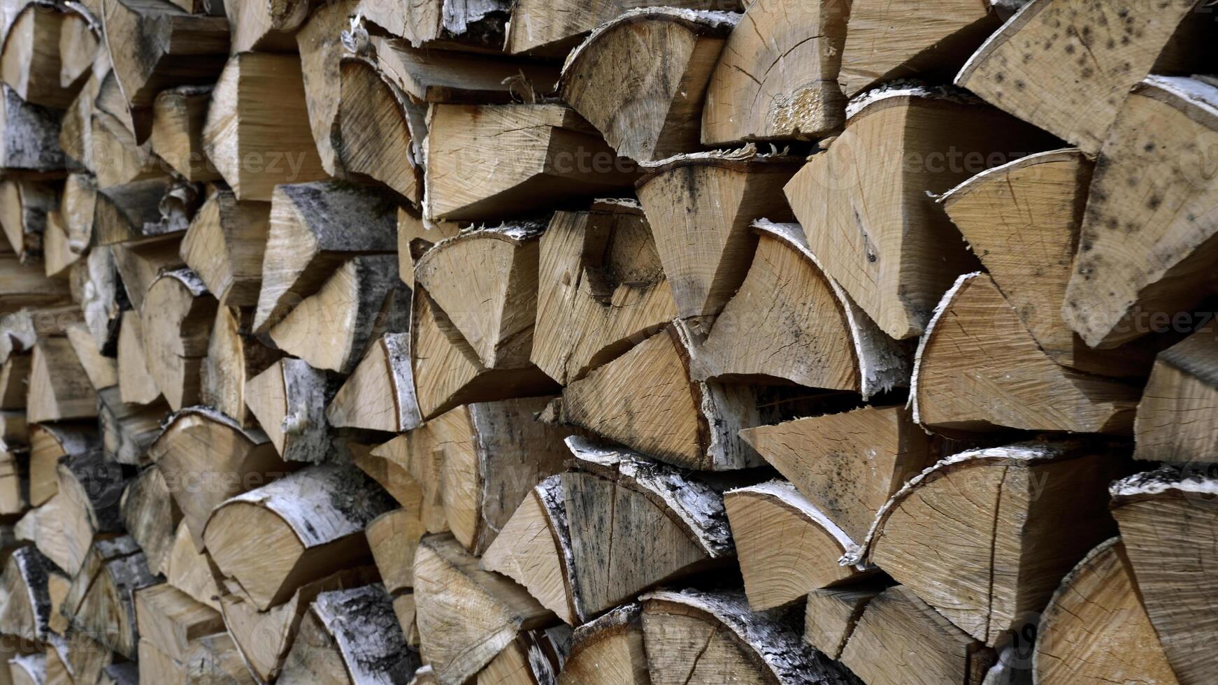 Close up of dry chopped tree trunks are laid in rows. Media. Stacked firewood prepared for the fireplace and stove. photo