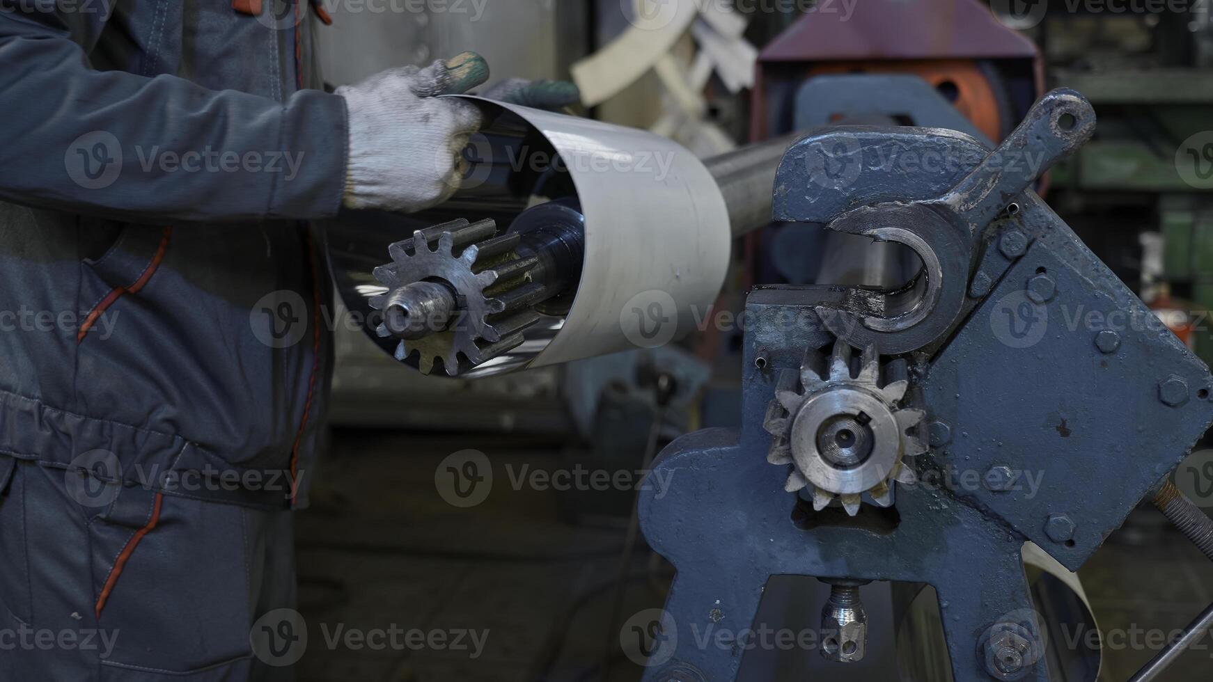 Metal rolling machine working in industrial workshop. Creative. Worker at a factory by a metal rolling machine bending a steel sheet. photo