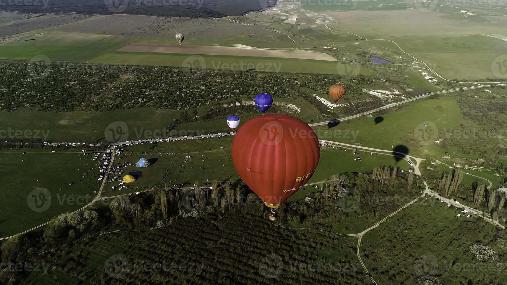 Aerial panoramic view of hot air balloons flight above summer green natural landscape. Shot. Exploring the beauty of nature above fields. photo