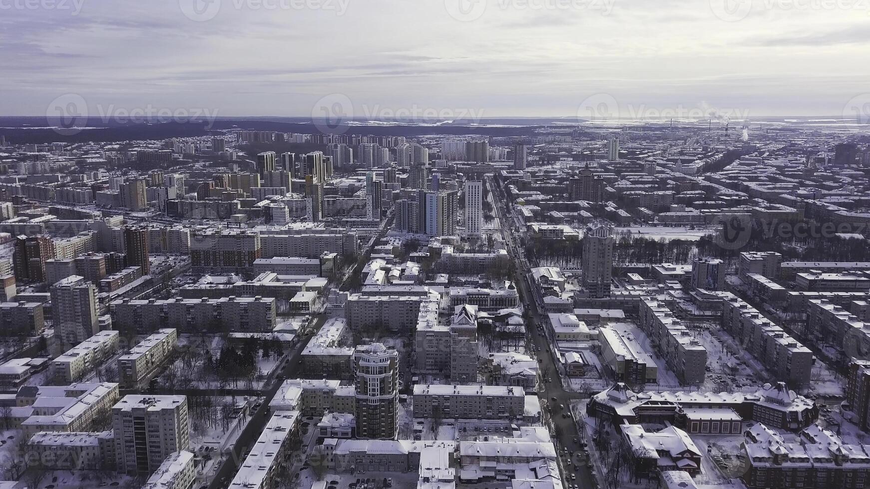 Aerial view of the city and many houses, roads, and yards in the winter time. Clip. Beautiful cityscape with different buildings, urban jungle concept. photo