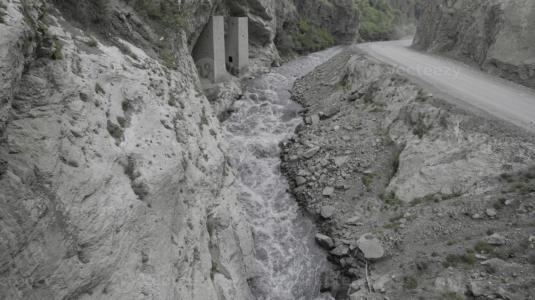 A powerful stream of water is squeezed between the sides of the rocks. Action. Aerial view of the river flowing in a gorge between mountains. photo