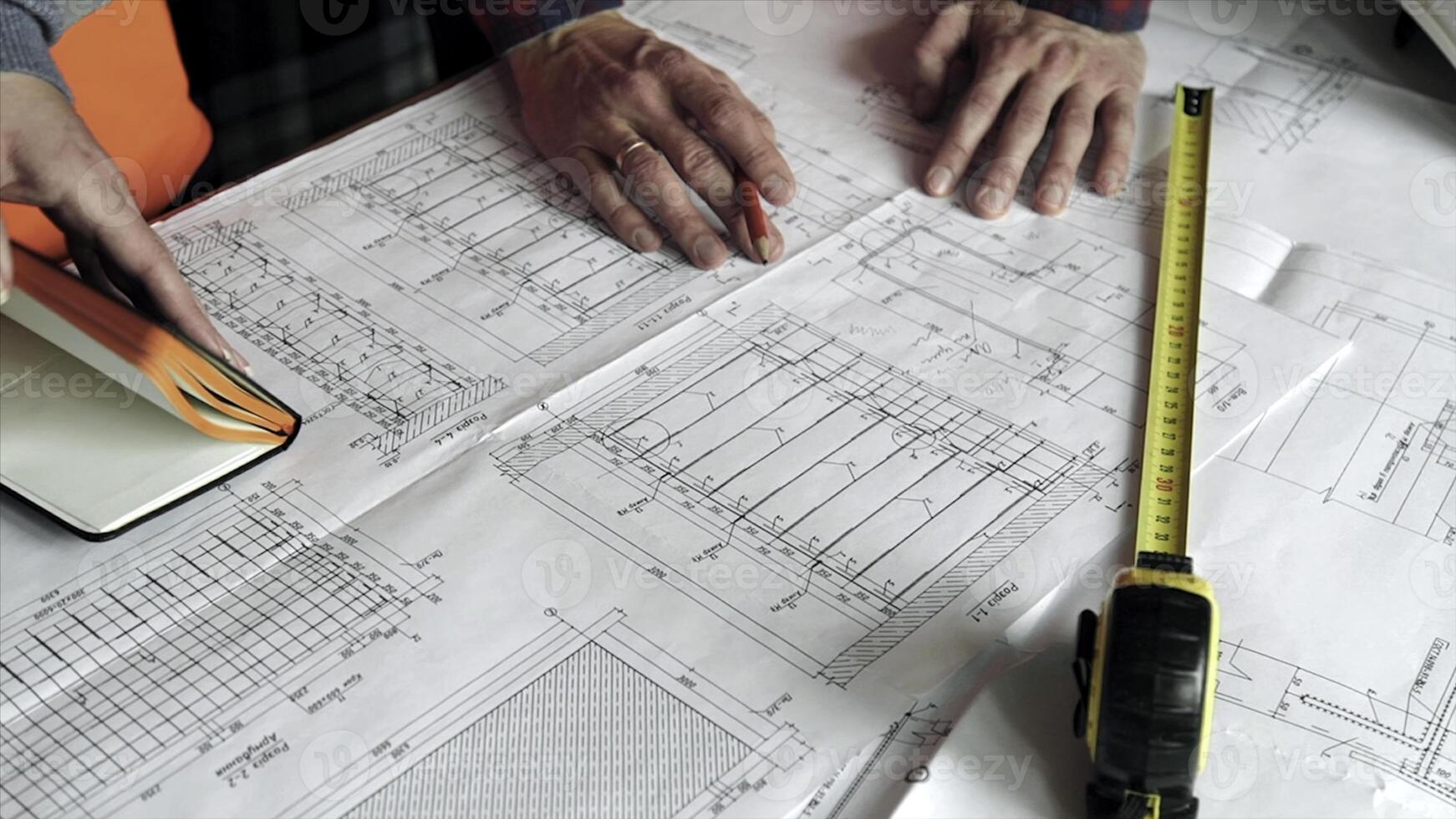 Close-up Of Person's engineer Hand Drawing Plan On Blue Print with architect equipment, Architects discussing at the table, team work. Stock. Close-up of hands with ruler and pencils on a draft photo