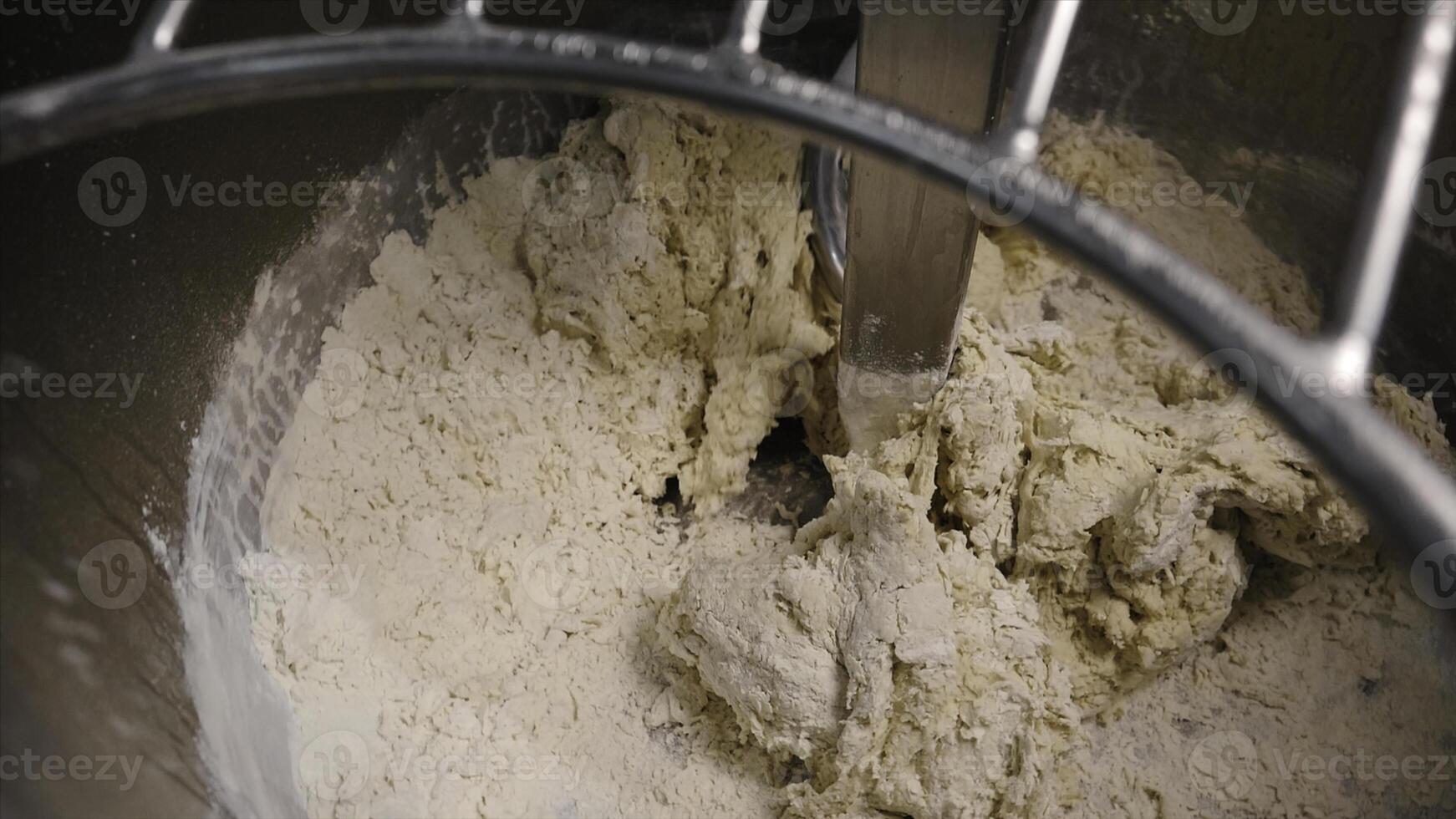Close-up of kneading dough in production mixer. Stock footage. Spiral kneader kneads fresh dough for baking in bakery photo