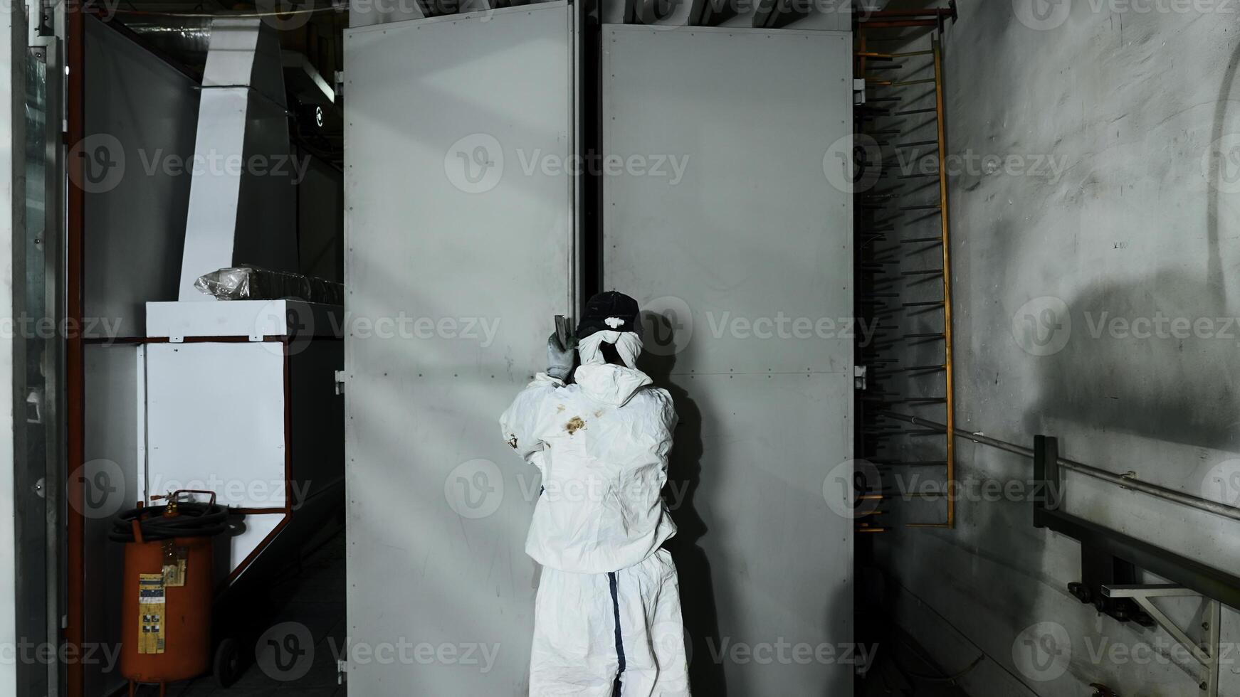 Worker pushing line of painted metal sheets into the drying chamber. Creative. Steel production plant. photo