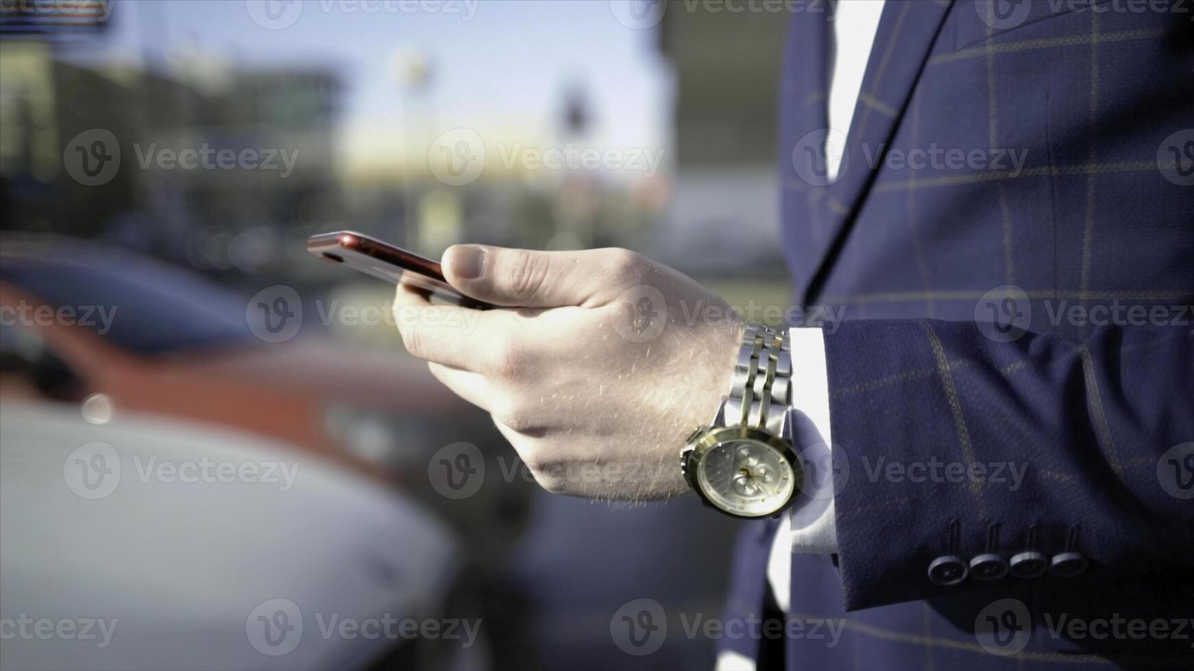 Close-up of businessman pressing car key. Action. Businessman opens car with electronic key and looks at phone. Modern car key to open and start it photo