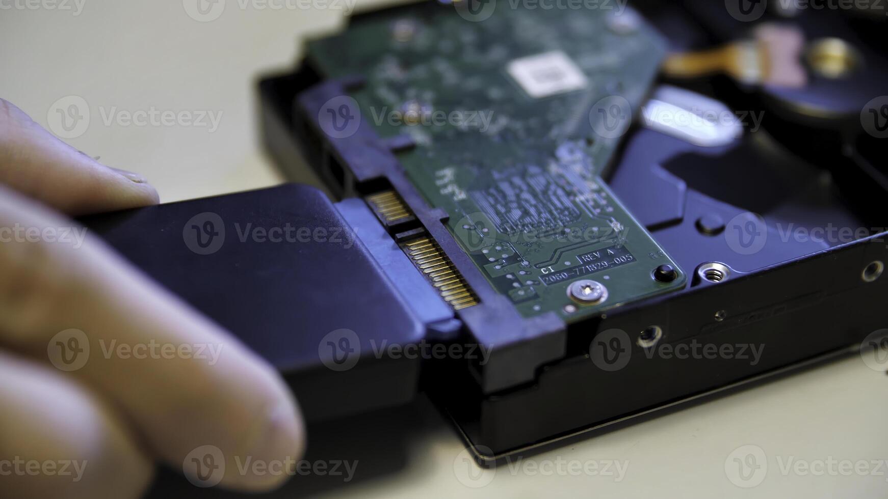 Close up of green electronic circuit board connected by the male hand to an external adapter. Media. Concept of modern technologies and engineering. photo