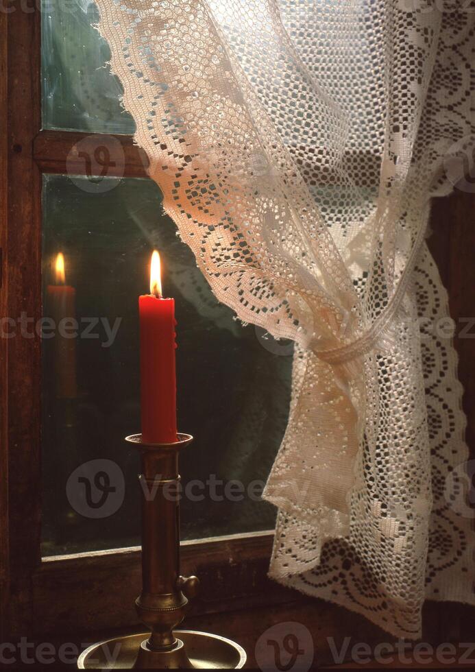 un vela es sentado en un mesa siguiente a un ventana foto