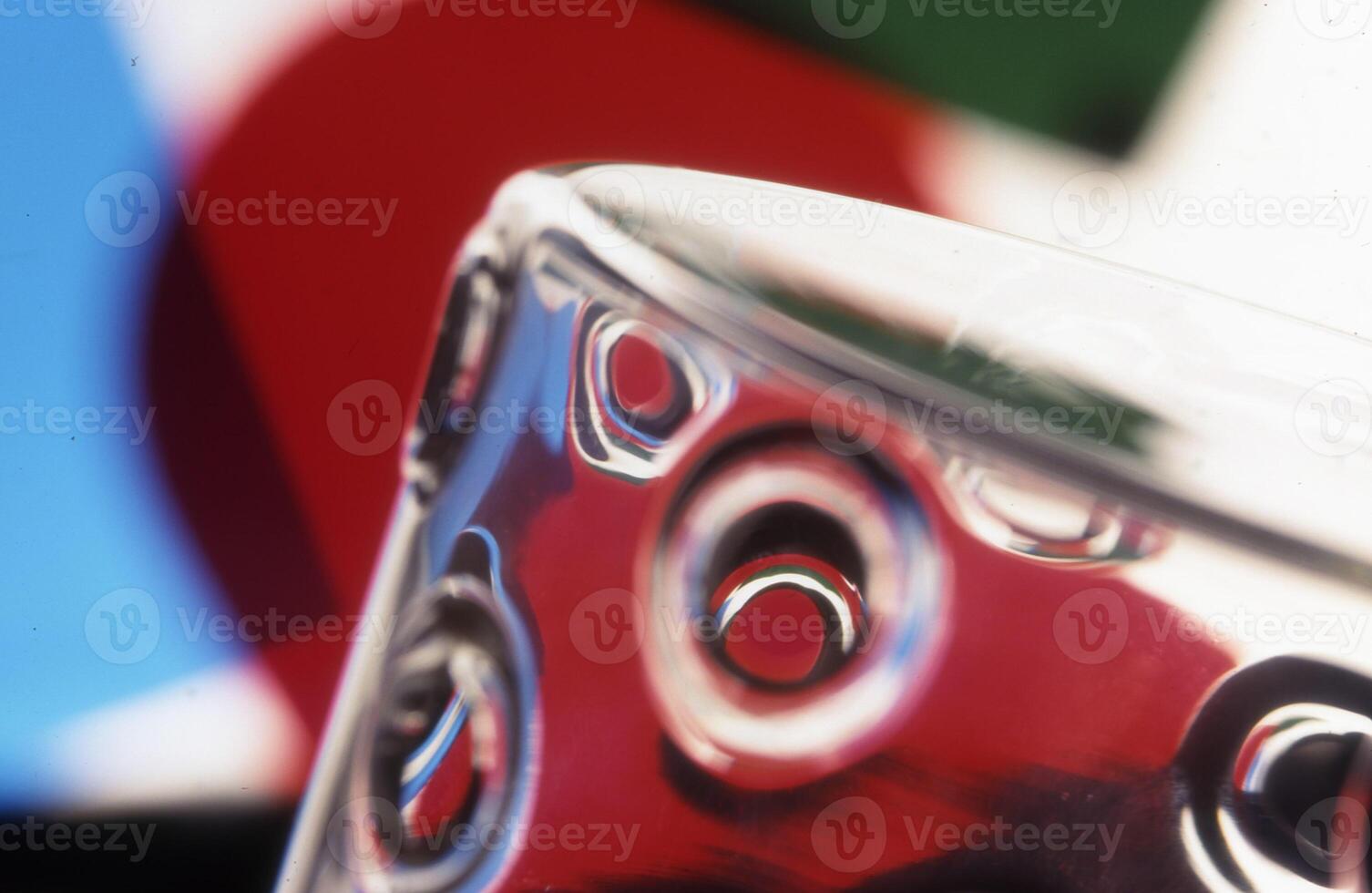 a close up of a glass with a red and blue background photo