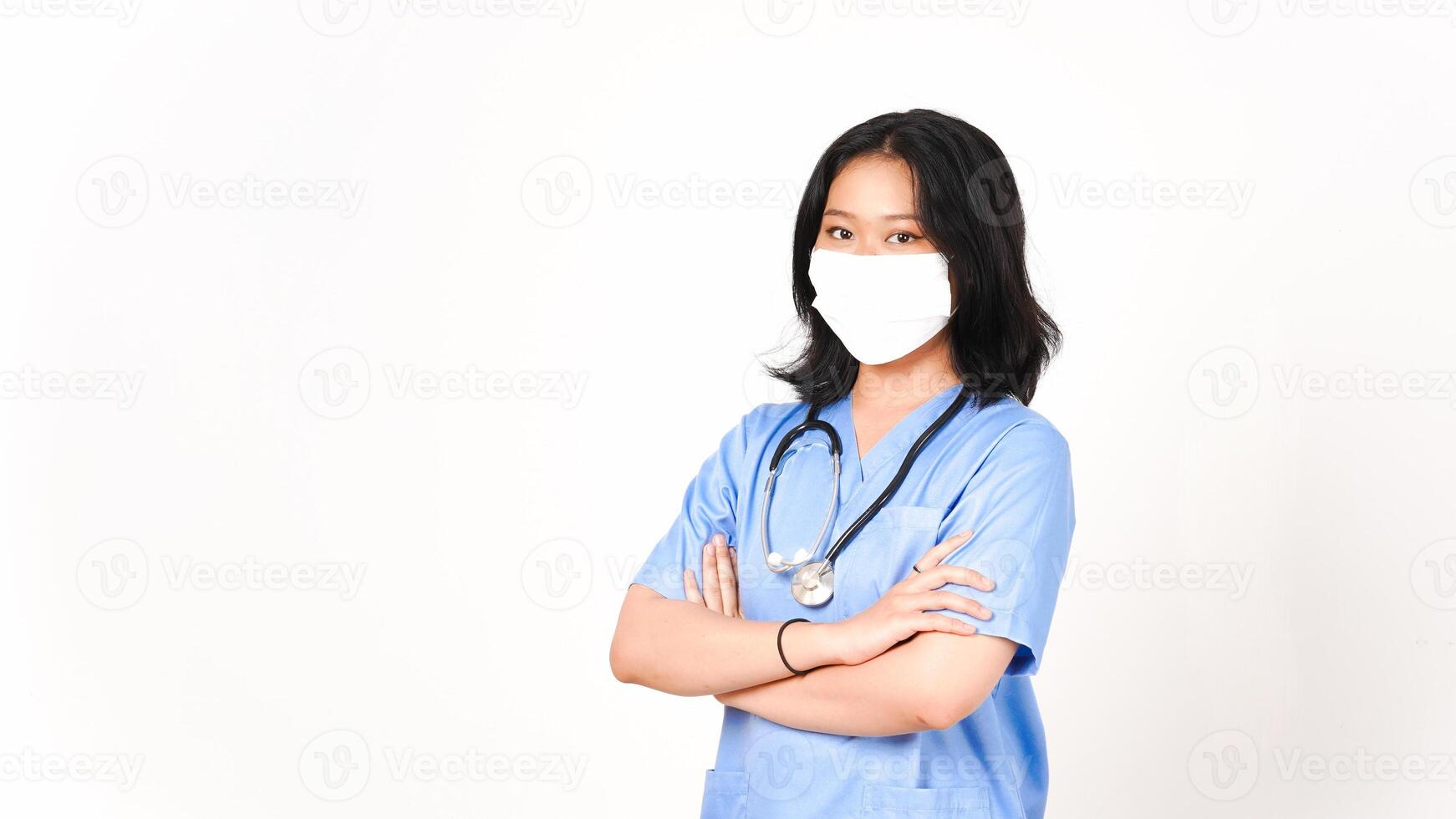 joven asiático hembra médico utilizando médico máscara participación brazos y mirando a cámara aislado en blanco antecedentes foto