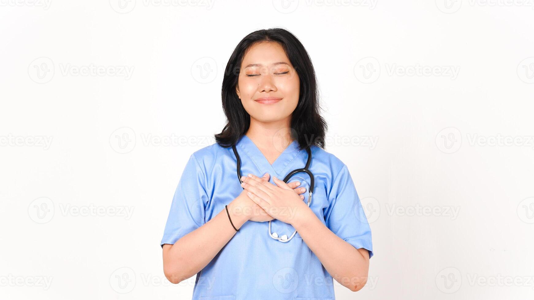Young Asian female doctor hand on chest grateful gesture isolated on white background photo