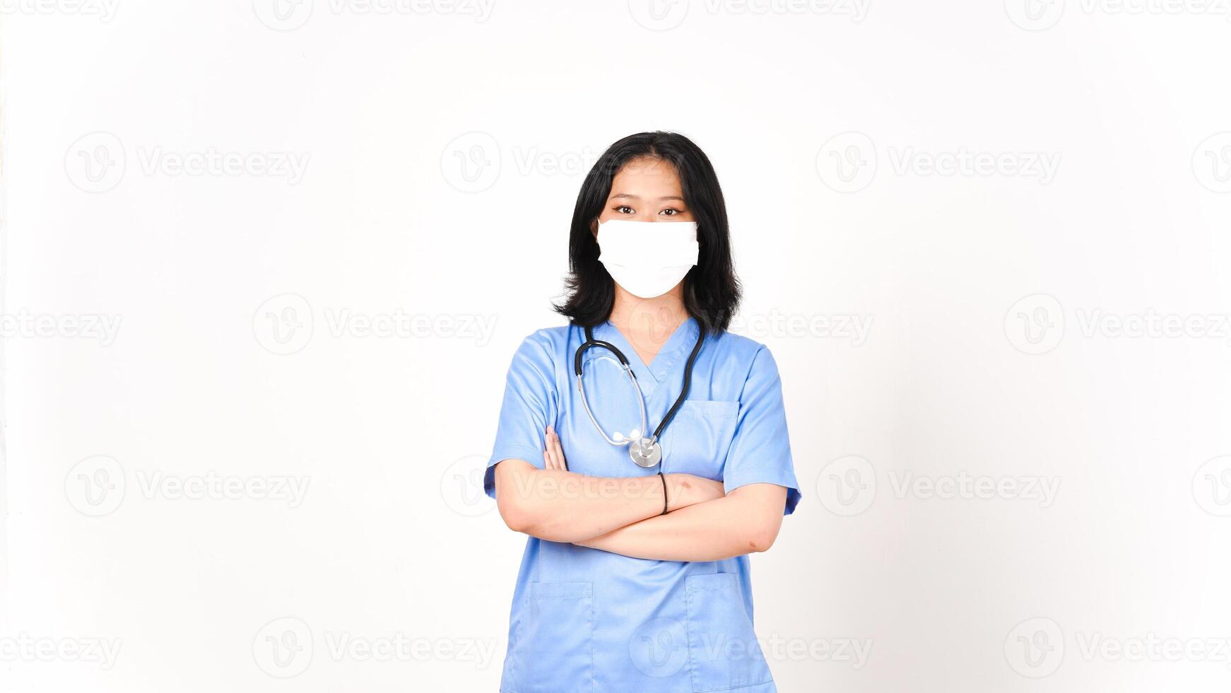 Young Asian female doctor using medical mask holding arms and looking at camera isolated on white background photo