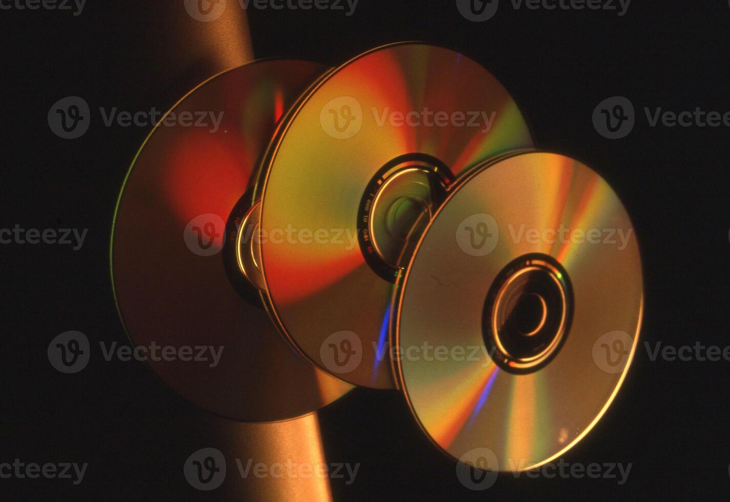 three cd's are shown in a dark room photo