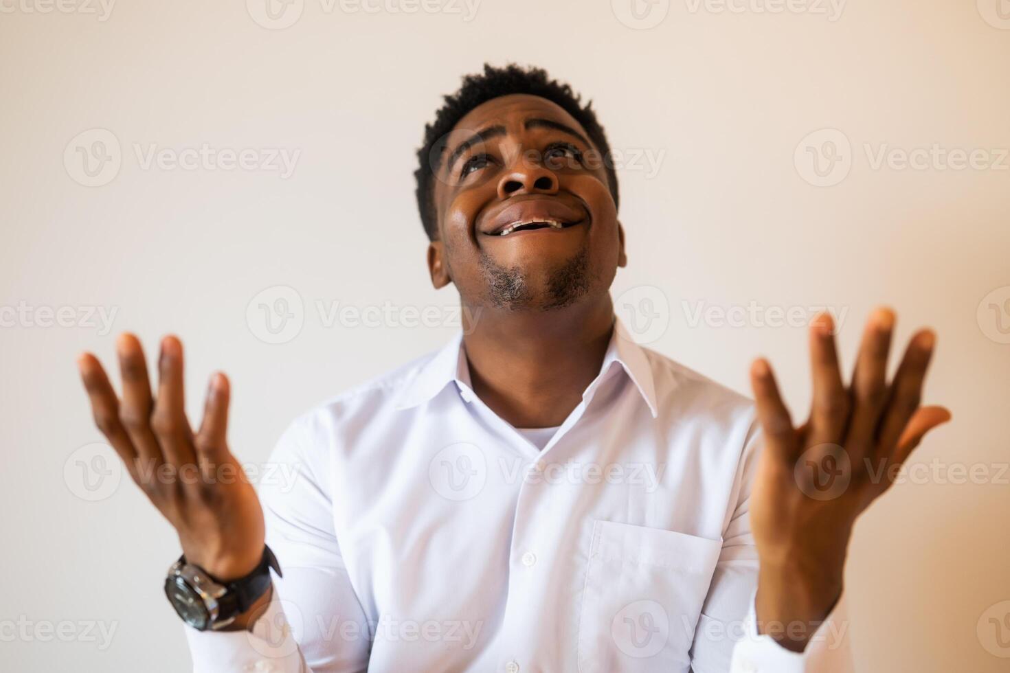 Portrait of young businessman who is disappointed and anxious. He is praying. photo