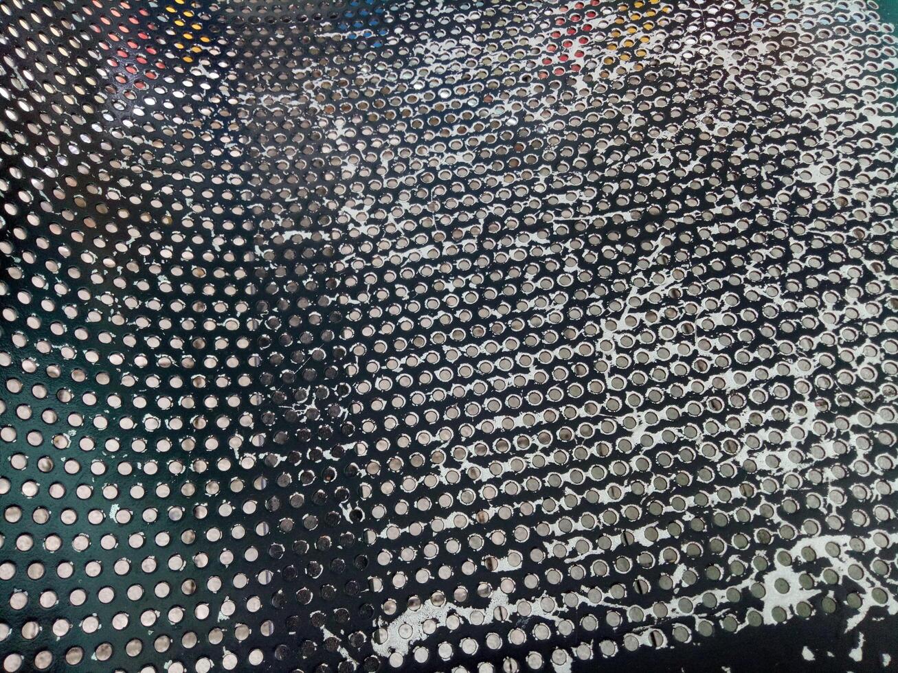 Texture of a black chair with lots of holes, peeling paint photo