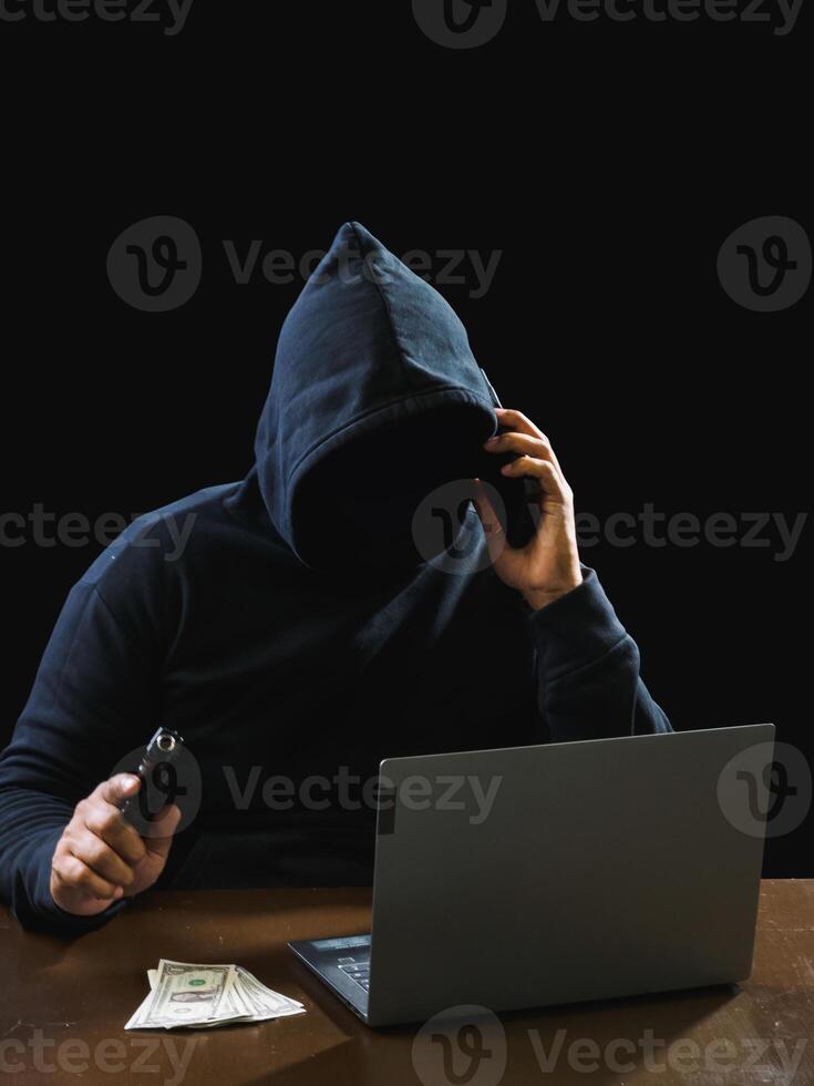 Portrait hacker spy man one person in black hoodie sitting on table looking computer laptop used login password attack security to data digital internet network system night dark background copy space photo