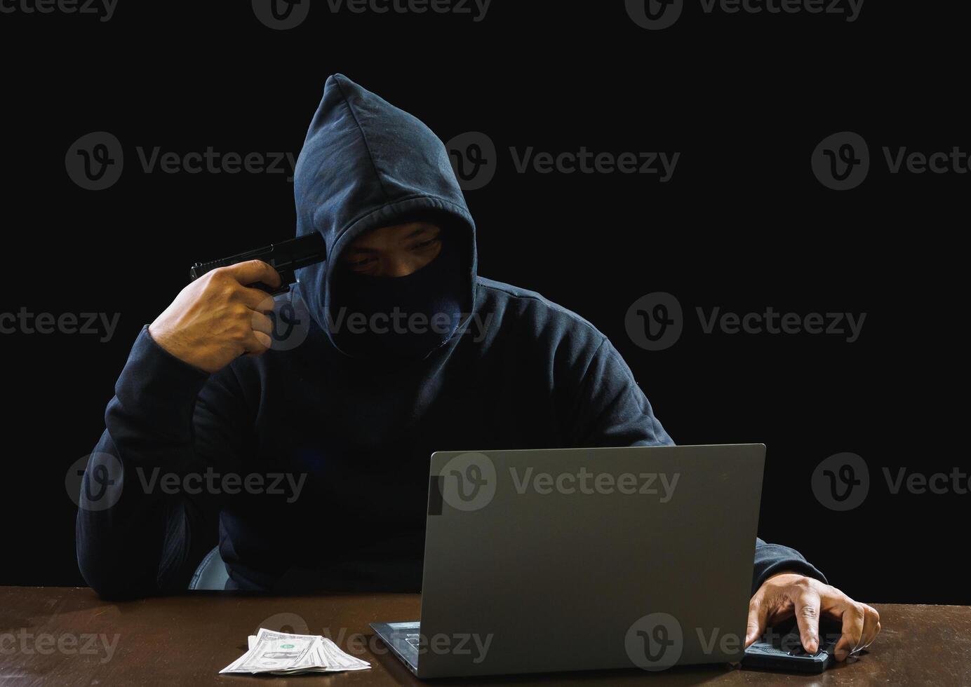 Portrait hacker spy man one person in black hoodie sitting on table looking computer laptop used login password attack security to data digital internet network system night dark background copy space photo
