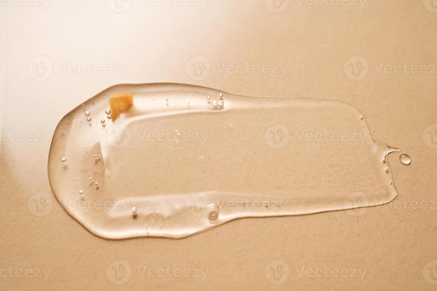 A drop of transparent cosmetic gel on a beige background. photo