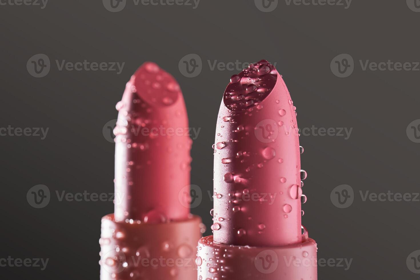 Red lipsticks with water drops on a dark background. photo