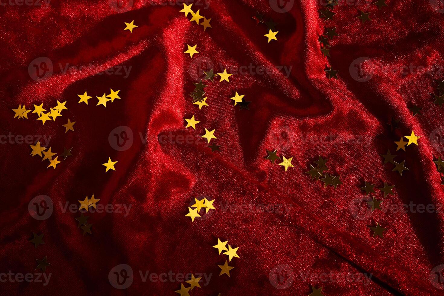 Abstract Christmas background with gold stars on a red velvet background. photo