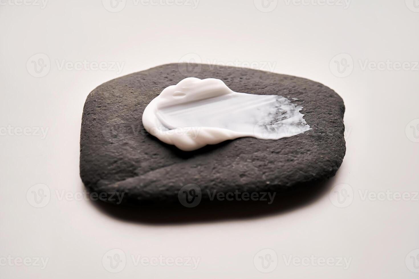 A smear of white cream on a black stone. photo