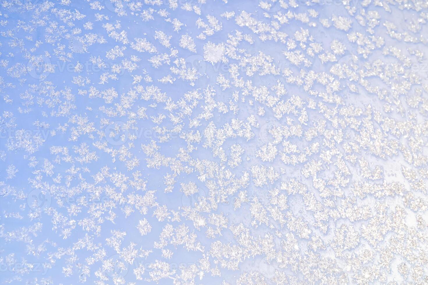 Abstract winter background. Frost on a frozen window against the blue sky. photo