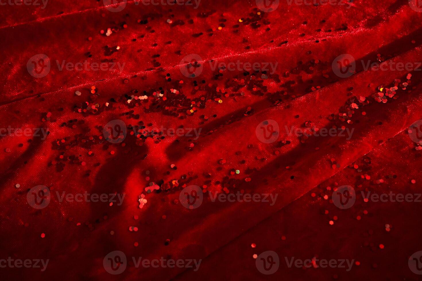 Abstract Christmas background made of red velvet fabric with red sparkles. photo