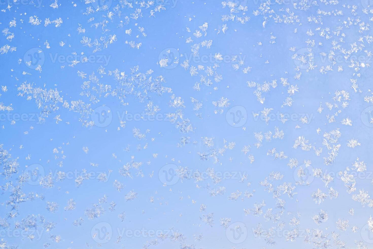 Abstract winter background. Frost on a frozen window against the blue sky. photo