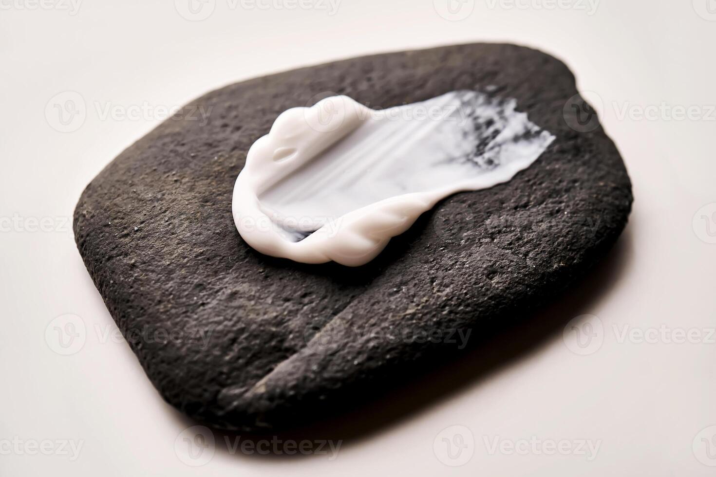 A smear of white cream on a black stone. photo