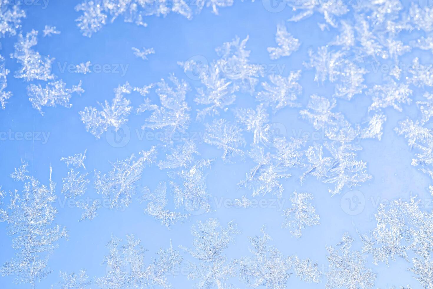 Abstract winter background. Frost on a frozen window against the blue sky. photo