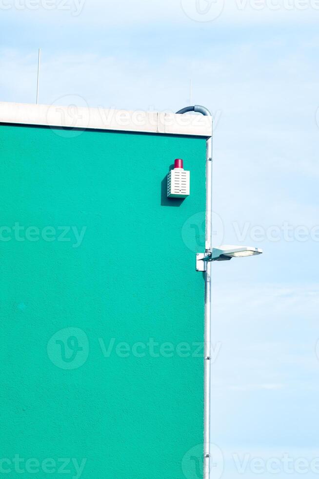 part of a green industrial building with lamp photo