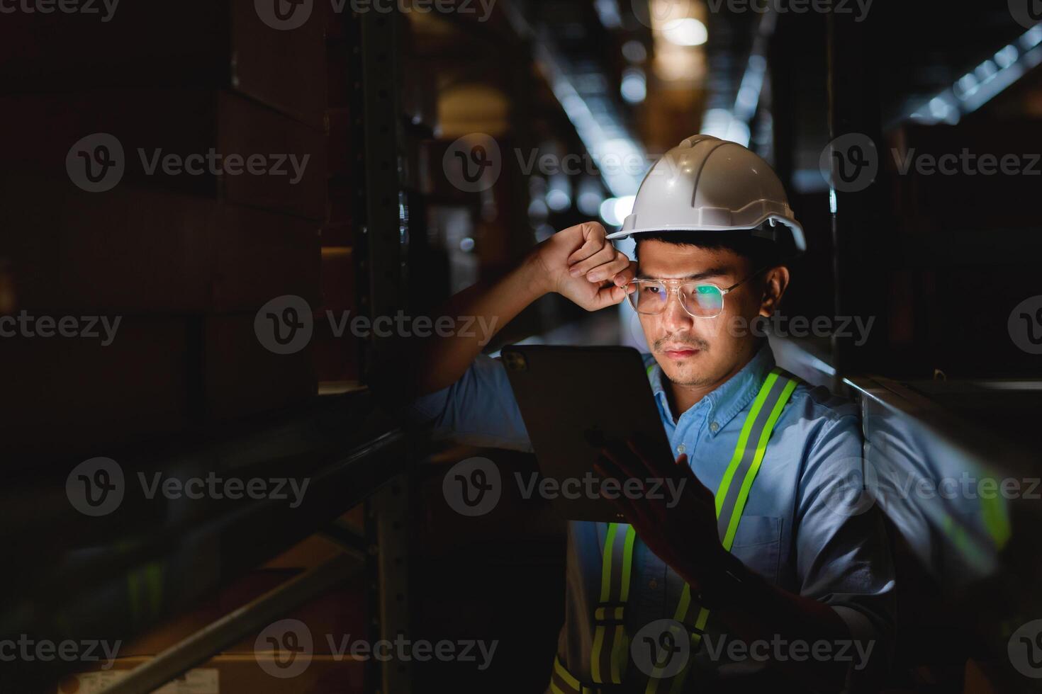 Stressed male manager or worker holding tablet and in warehouse A place to store ideas about workplace problems. Supply chain and warehousing concepts. photo