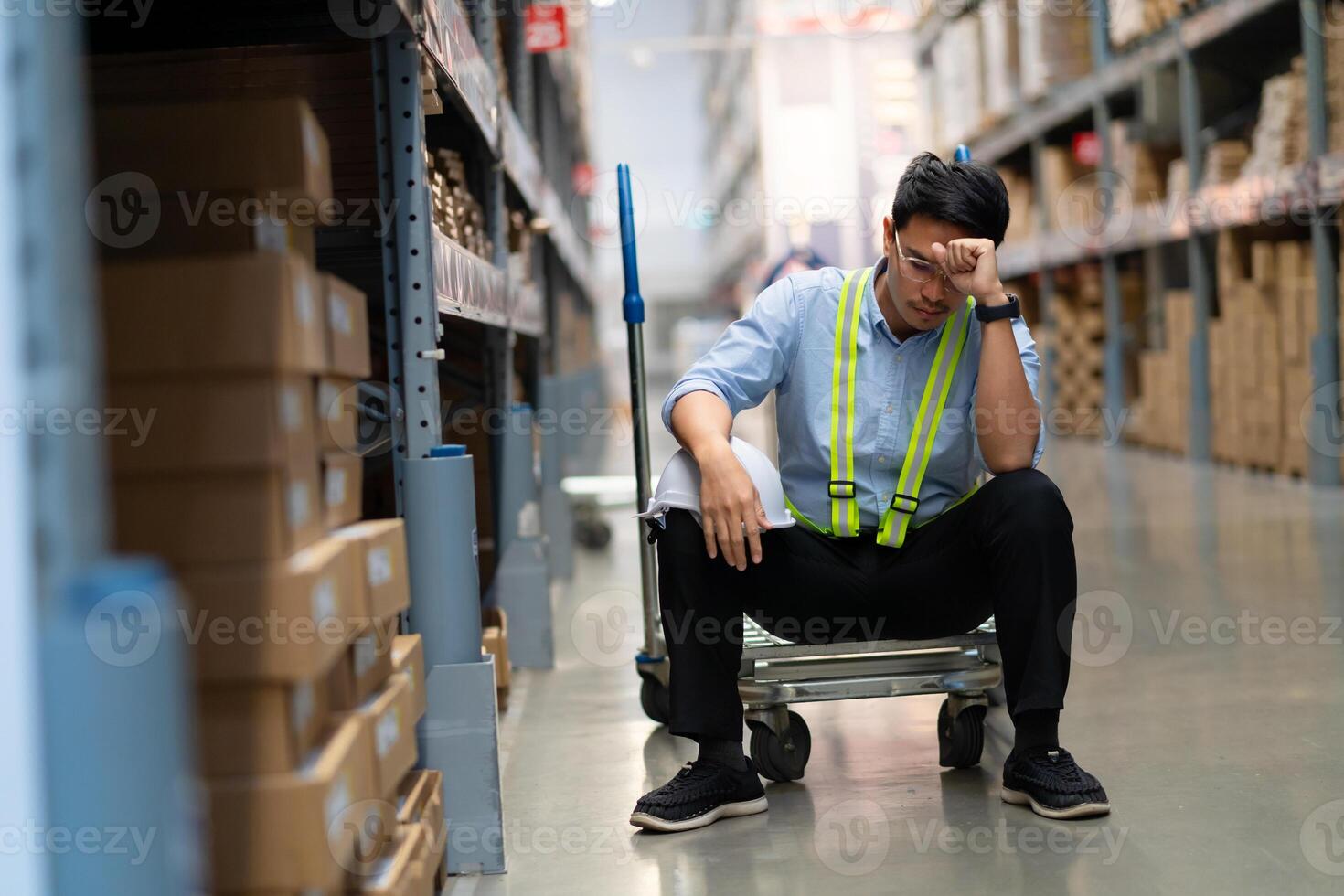 Asian warehouse worker who is unhappy after being fired from his job Unemployed people fail, hopelessness, depression. Workers are tired from work. photo