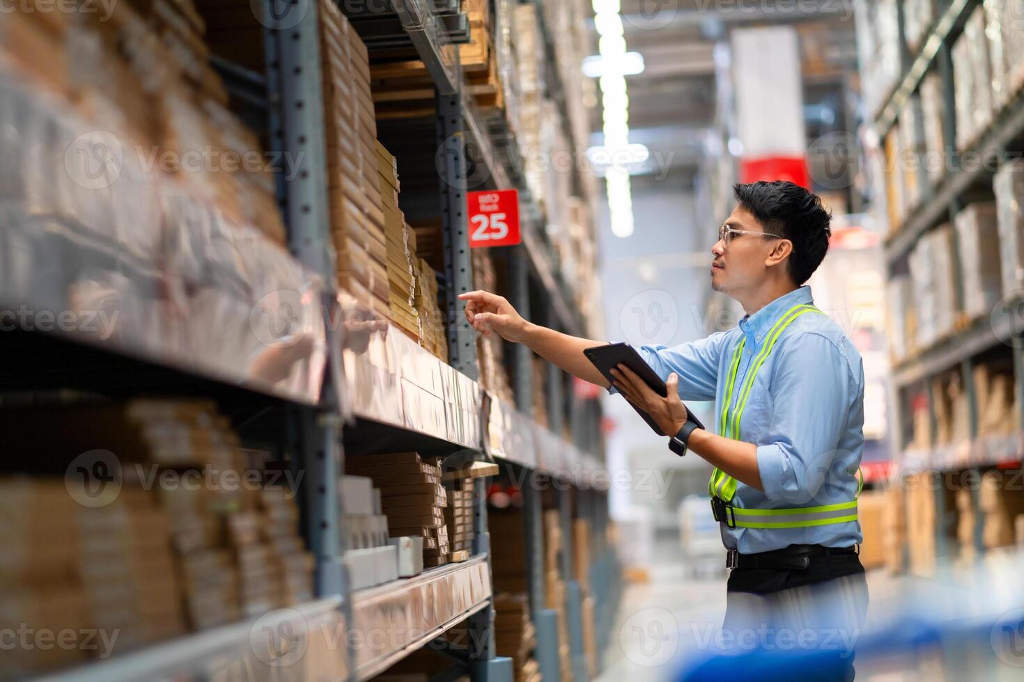 Warehouse worker in security uniform with tablet computer looking at merchandise in large warehouse Logistics and export business Logistics distribution center. photo