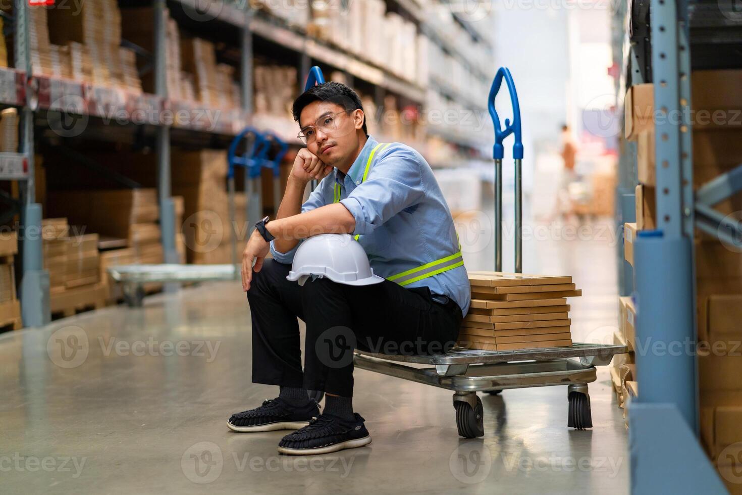 Asian warehouse worker who is unhappy after being fired from his job Unemployed people fail, hopelessness, depression. Workers are tired from work. photo