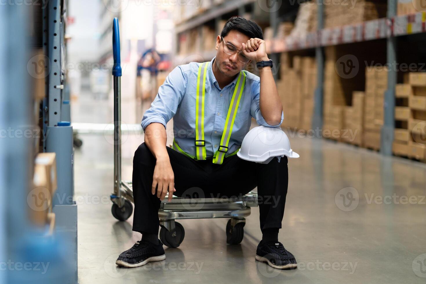 Asian warehouse worker who is unhappy after being fired from his job Unemployed people fail, hopelessness, depression. Workers are tired from work. photo