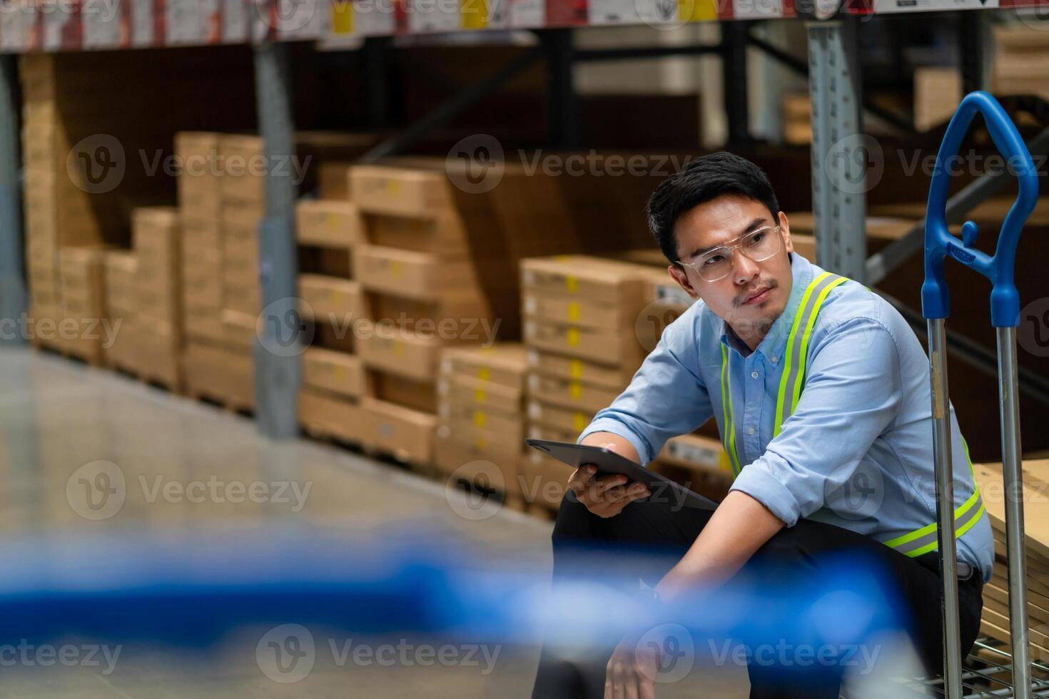 Asian warehouse worker who is tired from work. Being fired from work. Unemployed. Failed. Hopeless. Burned out at work. photo