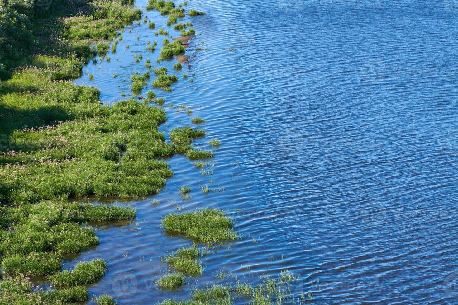 Coast of sea island edge, aerial top view. Densely green jungle peninsula, copy space. Pure, clean and calm blue water. Virgin nature. photo