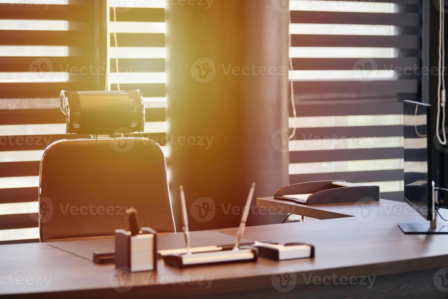 Business office workplace. Work place for chief, boss or other employees. Table and comfortable chair. Light through the half open blinds photo