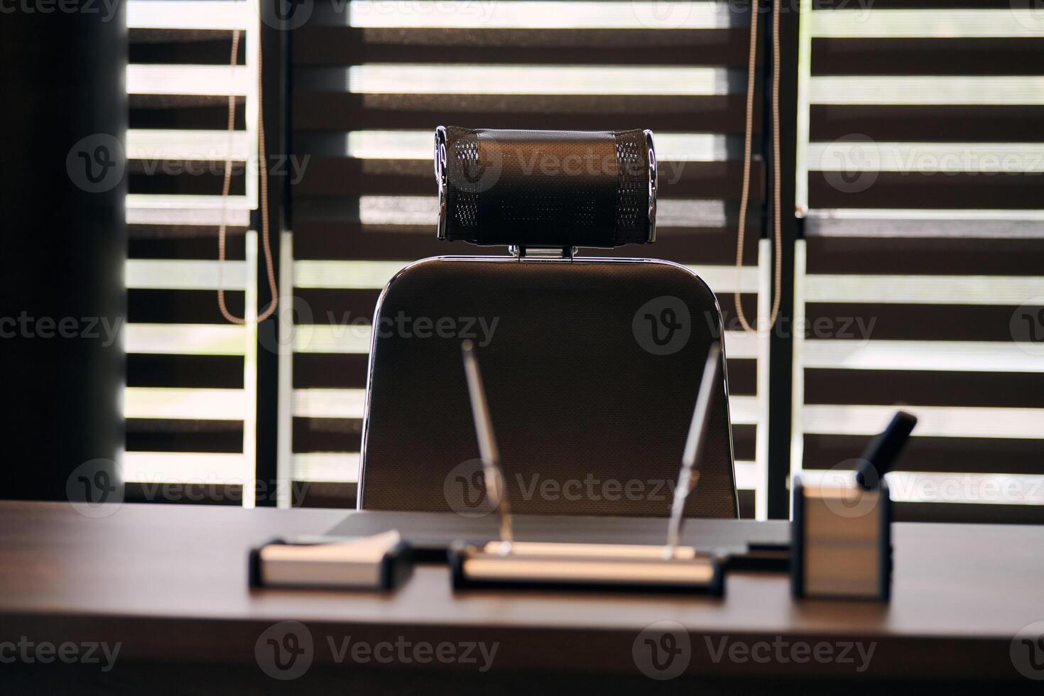 Business office workplace. Work place for chief, boss or other employees. Table and comfortable chair. Light through the half open blinds photo