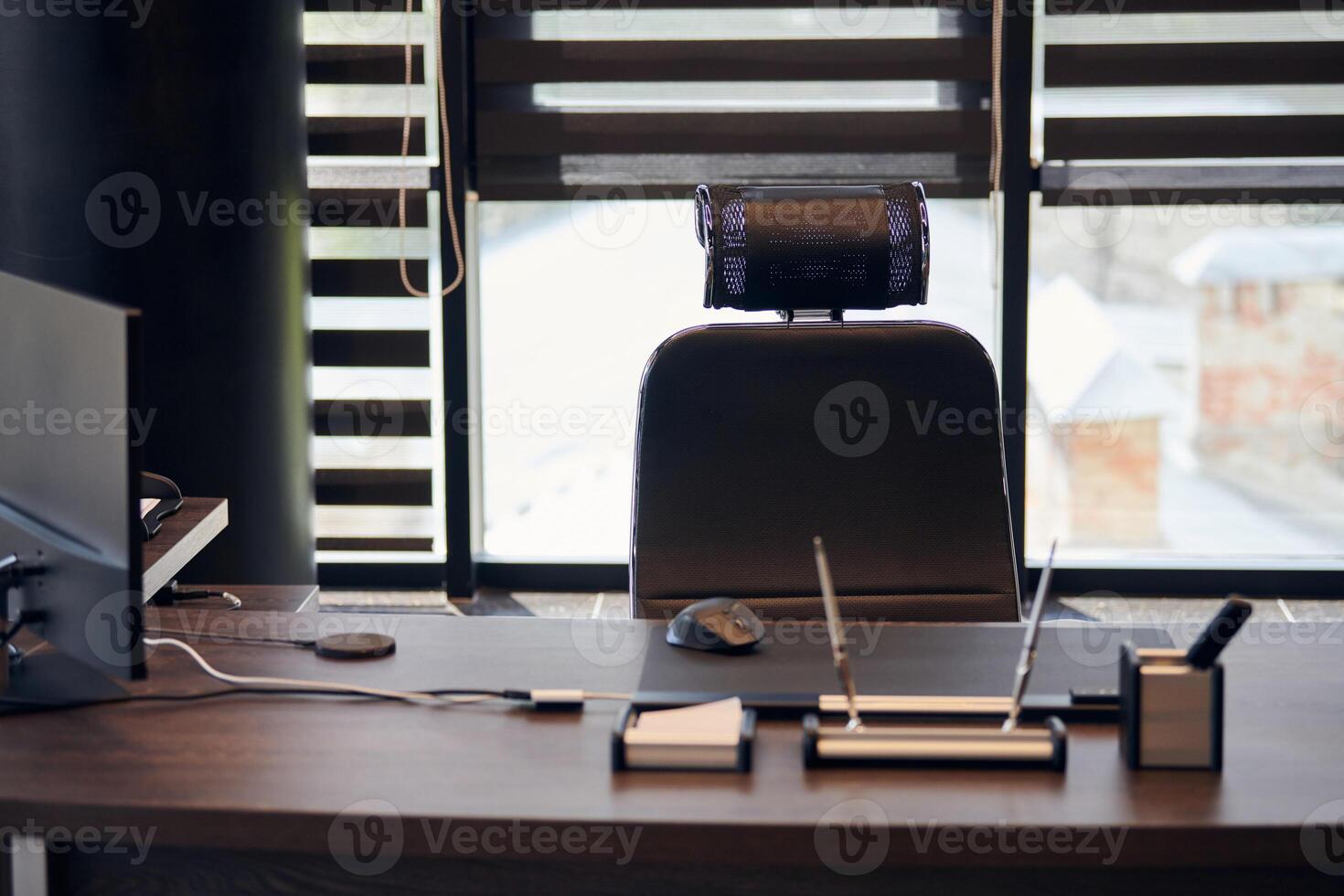 Business office workplace. Sunlight at work place for chief, boss or other employees. Table and comfortable chair. Light through the half open blinds photo