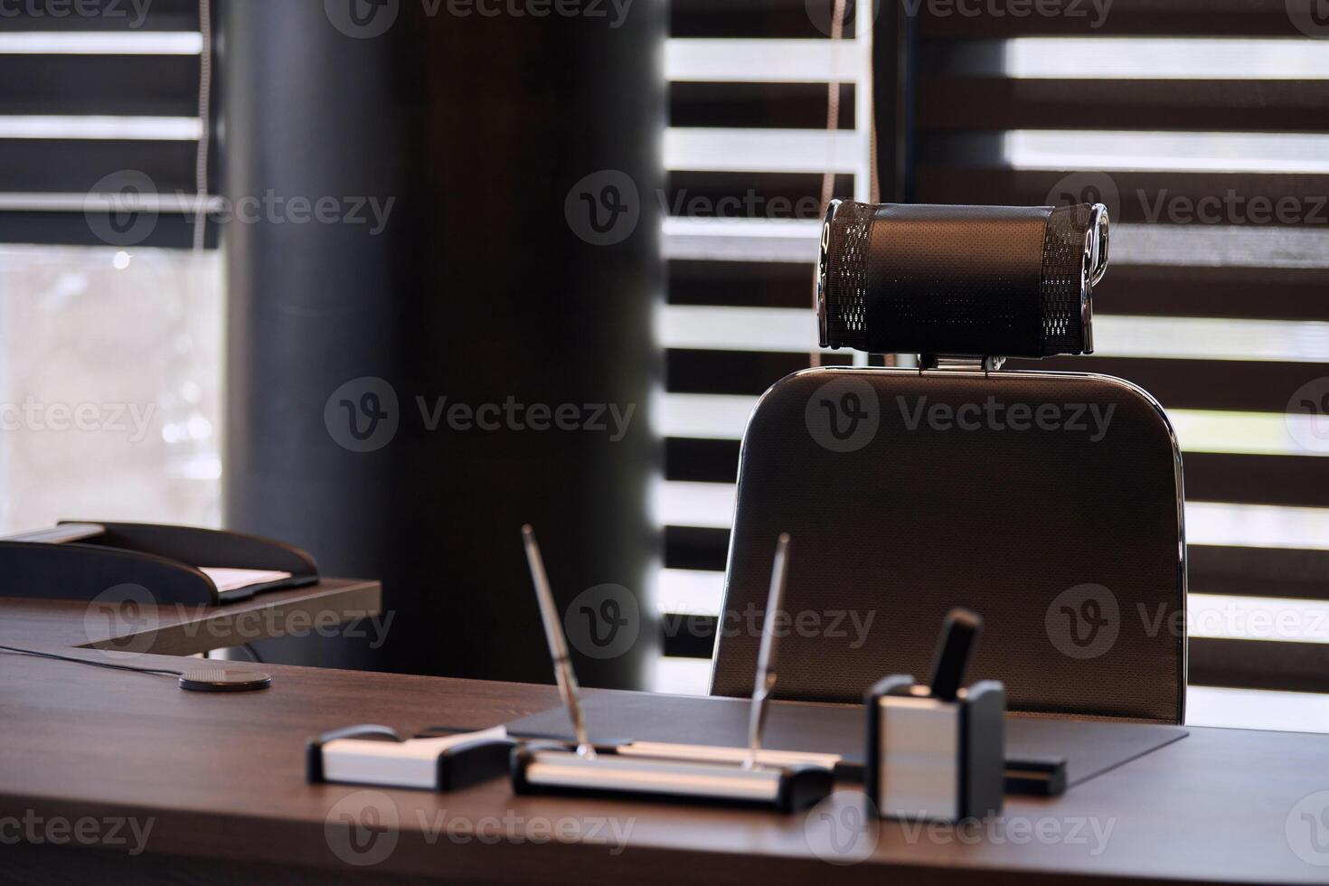 Business office workplace. Work place for chief, boss or other employees. Table and comfortable chair. Light through the half open blinds photo