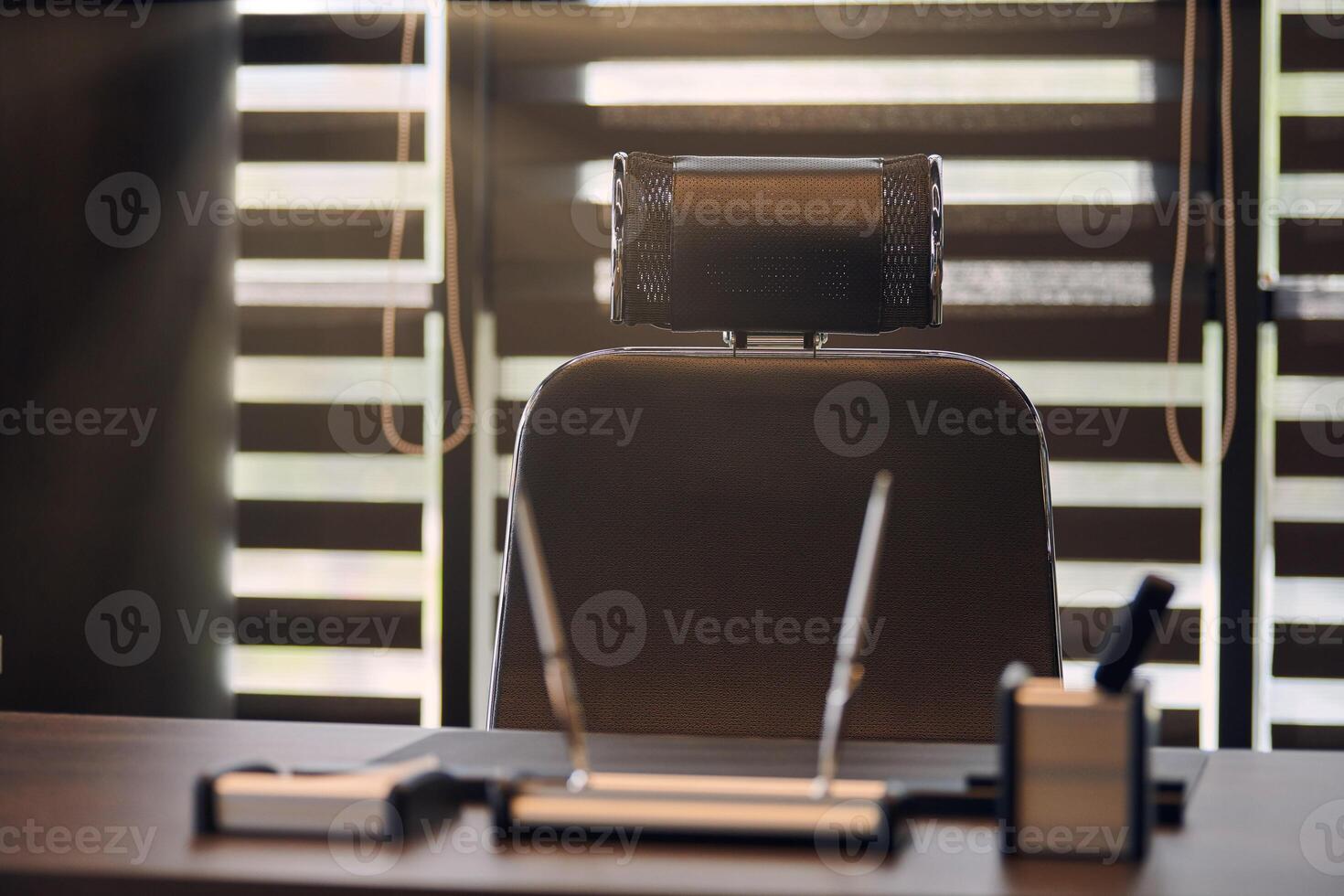 lugar de trabajo de la oficina de negocios. luz solar en el lugar de trabajo para jefe, jefe u otros empleados. mesa y silla cómoda. luz a través de las persianas entreabiertas foto