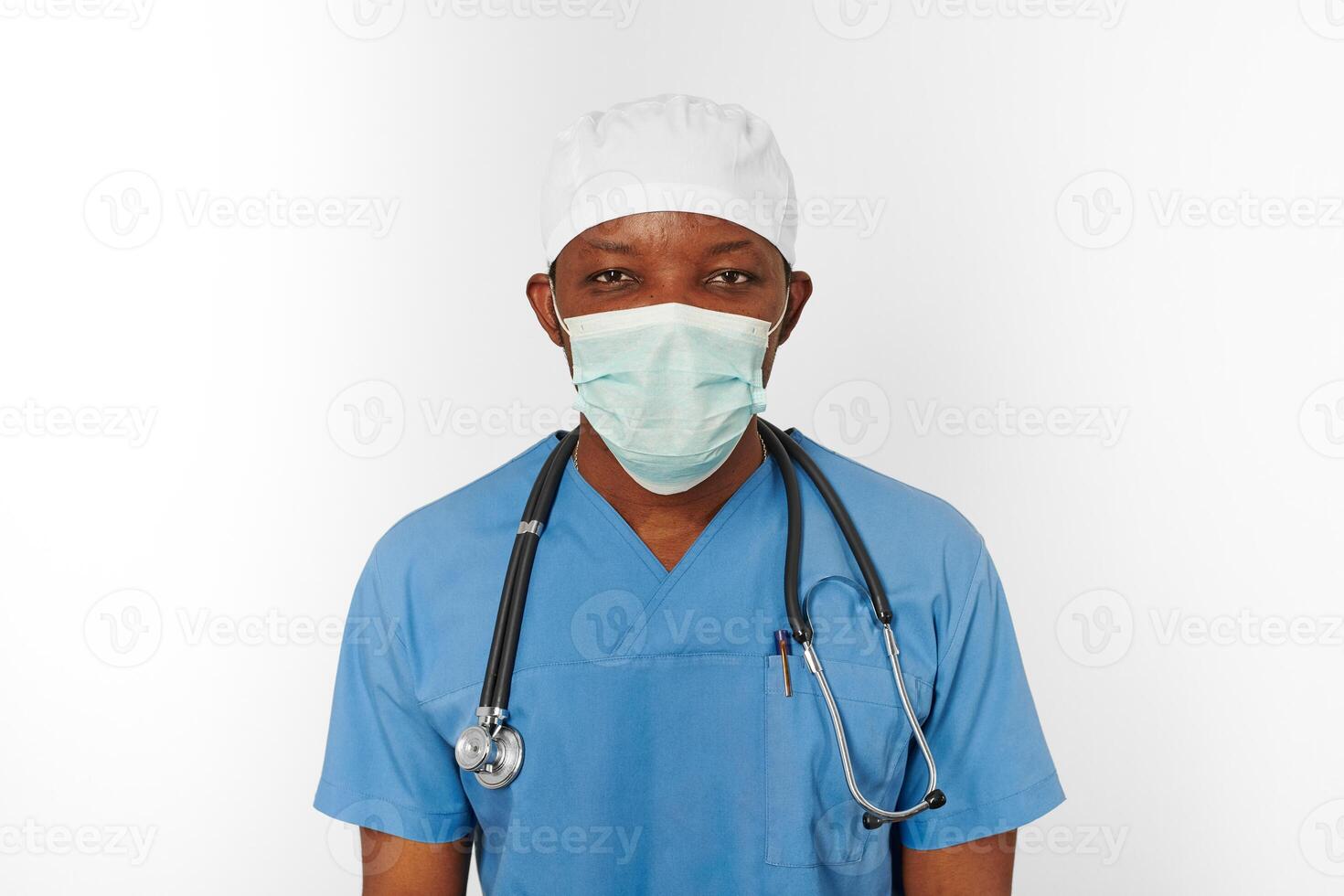 Black surgeon doctor man in blue coat white cap and surgeon mask with stethoscope white background photo